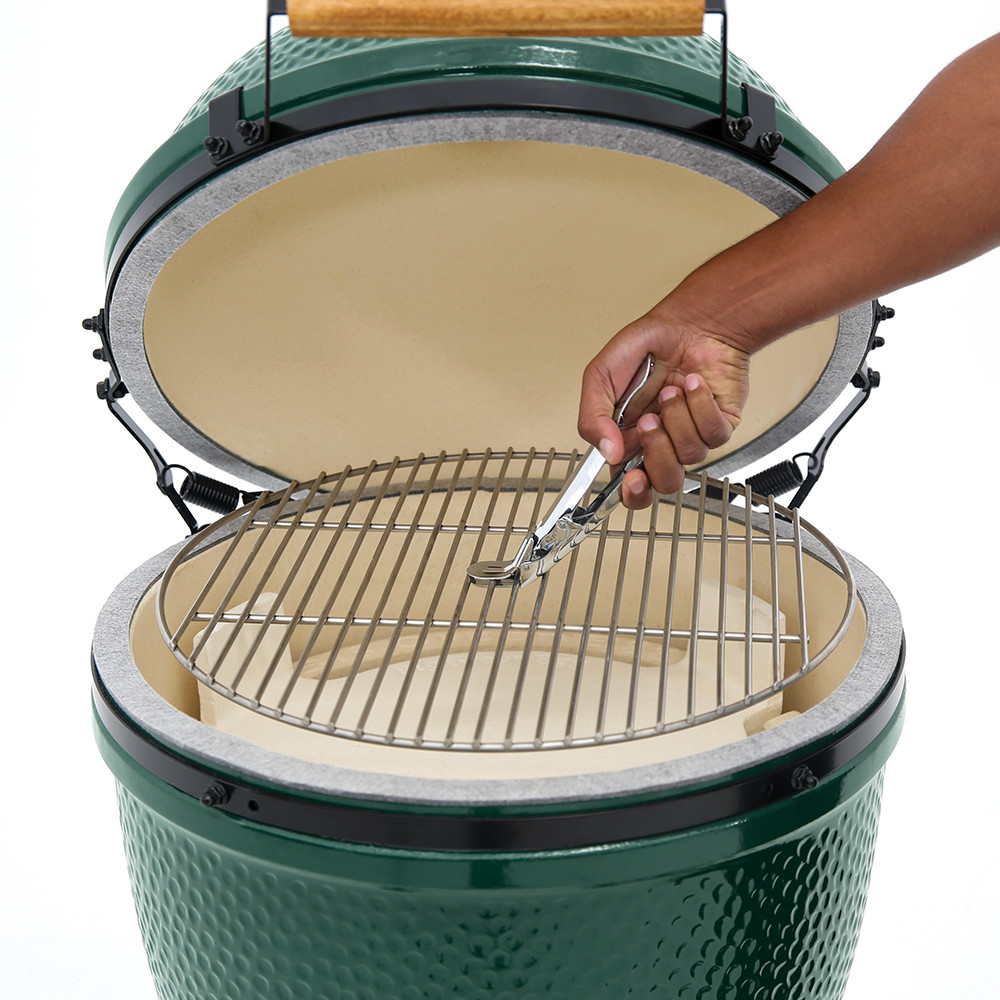 Hand using the Grid Gripper to remove the stainless steel cooking grid from MiniMax