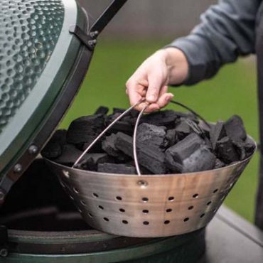 Man with Fire Bowl filled with charcoal putting it into the EGG